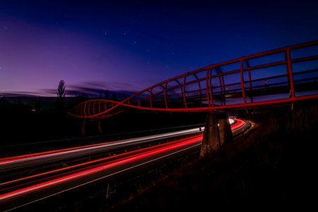 Night on highway and car lines with pedestrian bridge Cat eyes near Chlumec north Bohemia town