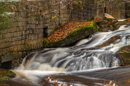 Valley of river Cerna Nisa and small waterfalls in autumn cloudy morning
