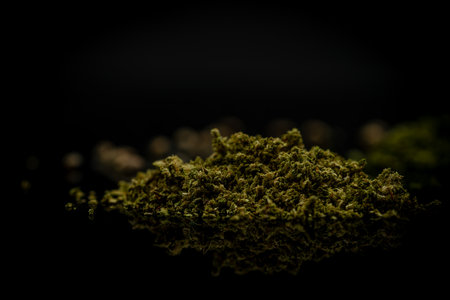 Three varieties of grind dry marijuana bloom with small seeds on dark black floorの写真素材