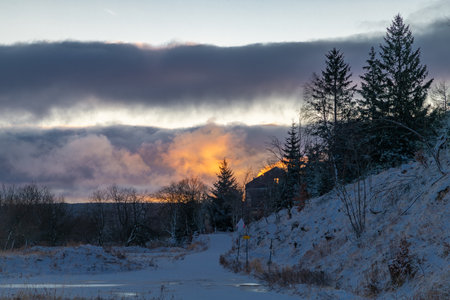 Cold winter morning with sunrise near old station in mountains in Moldava villageの写真素材