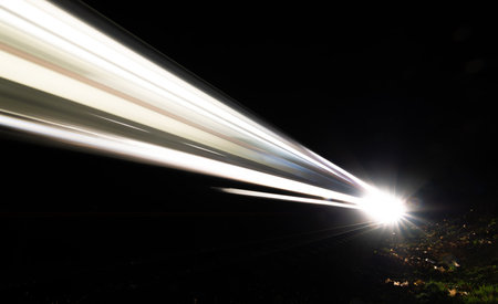 White light lines from train engine in dark night near Znojmo hospital railway stopの写真素材
