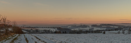 Winter frosty color view for sunset over road to Semily with silhouette of treesの写真素材