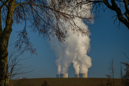 Big chimneys with white smoke in winter sunny day near nuclear power plant in south Bohemia