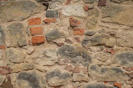 Old brick stone wall house with holes and sunny hot dayの写真素材