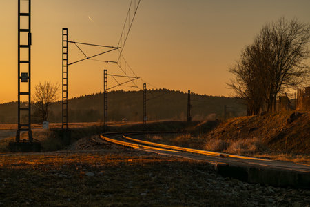 Railway crossing with red lights with sunset in winter evening near Trocnovの写真素材