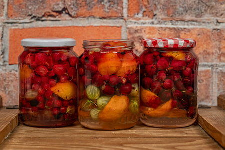 Fruit mix compote on wooden box near red brick old wall