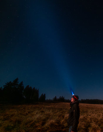 Autumn full moon night with clear sky in Krusne mountains with head lampの写真素材
