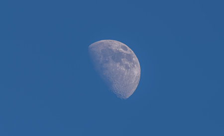 Half moon in sunny day with clear blue sky