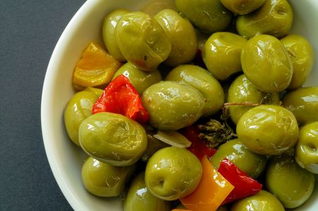 Olives seasoned with sweet pepper, garlic and spices in dish (horizontal)の写真素材