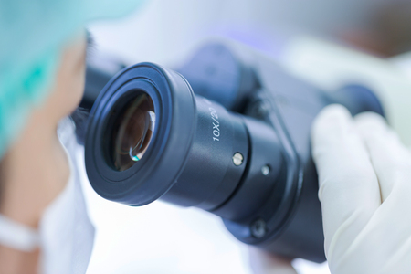 Scientist using a microscope in a laboratoryの写真素材