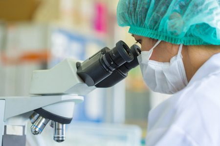 Scientist using a microscope in a laboratory