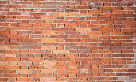red old brick wall with gray cement jointsの写真素材