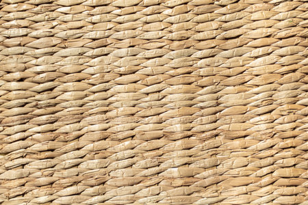 background of light yellow mat woven from reedsの写真素材