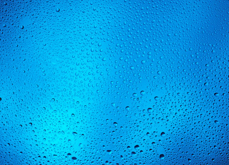 Glowing blue background with contrasting water dropsの写真素材