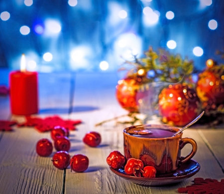 Christmas still life, a cup of hot chocolate on a wooden table surrounded by Christmas toys.Glowing blue backgroundの写真素材