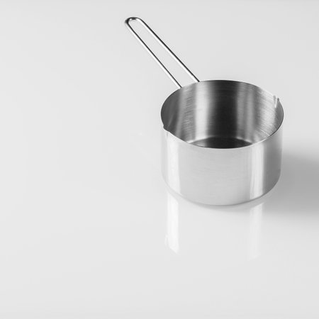 Kitchen utensils.Small stainless steel ladle on glass white backgroundの写真素材
