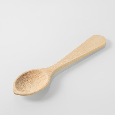 Wood kitchen utensils. Wooden tea spoon on a white mirror backgroundの写真素材