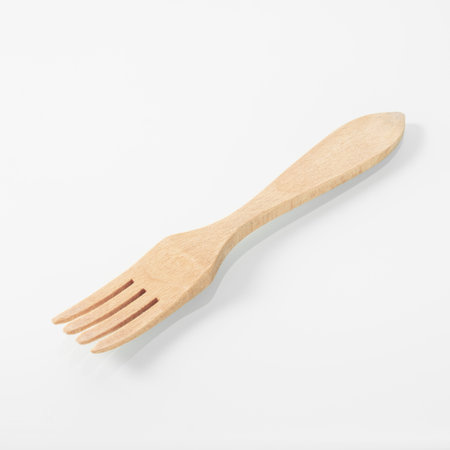 Wood kitchen utensils. Wooden fork on a white mirror backgroundの写真素材