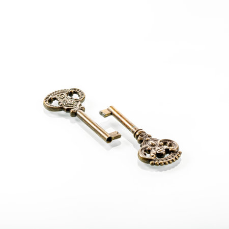 Two old bronze keys with reflection in a white mirror backgroundの写真素材