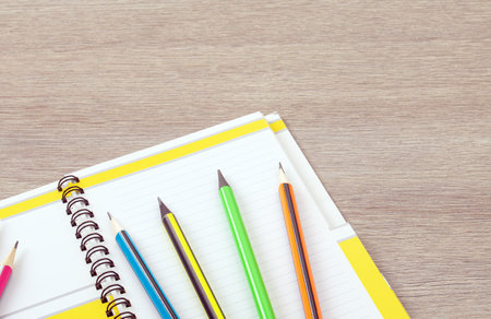 office theme. Simple pencils with a multi-colored shell lie like a fan on an open notebookの写真素材