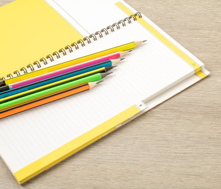 office theme. Simple pencils with a multi-colored shell lie on an open notebook in a rowの写真素材