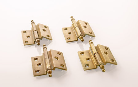 Four brass furniture hinges from the early 20th century with traces of patinaの写真素材