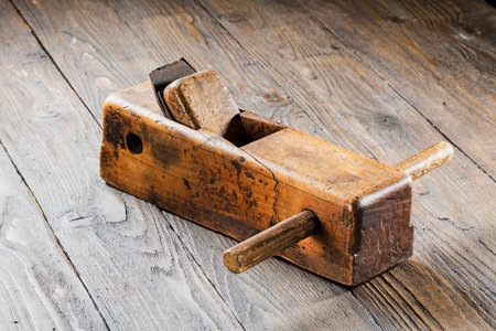 Old planer with signs of wear and age on a dark wooden background.の写真素材