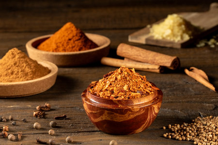 Various spices in cork saucers on a wooden kitchen tableの写真素材