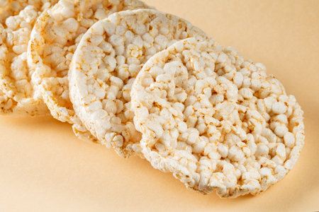 Rice cakes stacked in a diagonal row on a beige background.