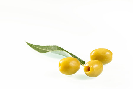 Three green olives on a white background close-up.の写真素材