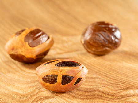 Three nutmegs on a bright wooden background.Close upの写真素材