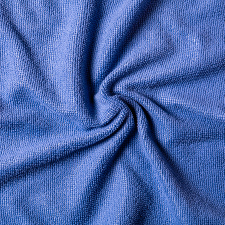 Abstract background of crumpled soft fabric of purple color, twisted in a spiral, close-up view from...