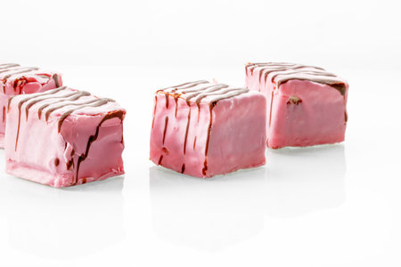 Punch cakes covered with pink icing on white background