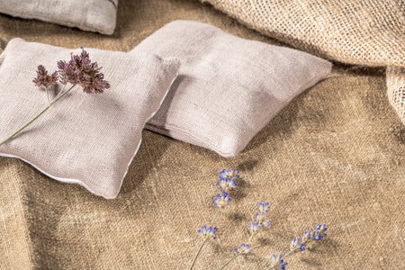 Create a warm and welcoming ambiance with this country-style decor featuring peasant pillows and dried lavender stems arranged on a burlap background, exuding a rustic and charming allure.の写真素材