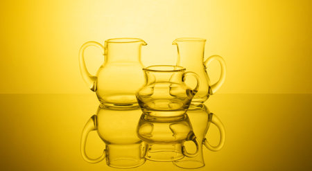 A stunning composition of elegant glassware arranged against a captivating glowing gradient background. The interplay of light and shadow creates a sophisticated and mesmerizing visual experience.の写真素材