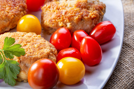 Plate with fried cutlets and cherry tomatoesの写真素材