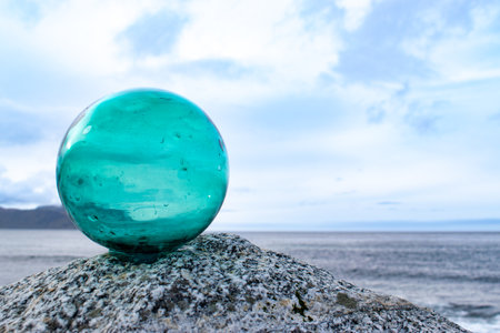 Glass ball on top of a boulder on the seashore, minimalismの写真素材