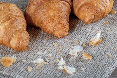 Croissants on a burlap napkin on a kitchen table.の写真素材