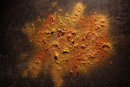 Bright spices scattered on black table, high contrast photo, flat layの写真素材