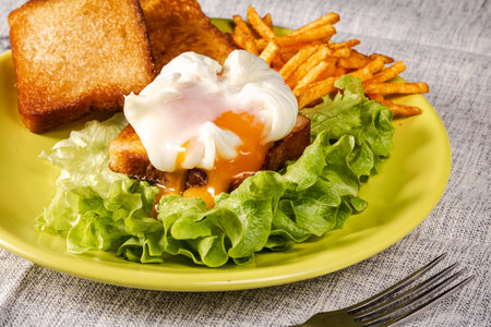 Poached egg with green salad, croutons and French fries.の写真素材