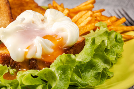 Poached egg with green salad, croutons and French fries.の写真素材