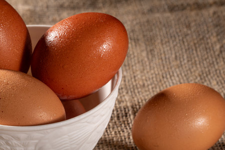 Experience the charm of homegrown chicken eggs displayed on rustic burlap. This image emphasizes the...