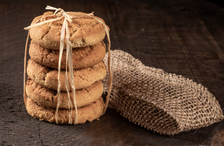 A delightful spread of freshly baked raisin cookies displayed on a rustic country-style table,...