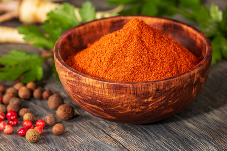 Artistic close-up showcasing vibrant red ground pepper in a beautifully crafted wooden bowl. The textured surface adds depth and warmth, enhancing the natural beauty of this culinary ingredient.の写真素材