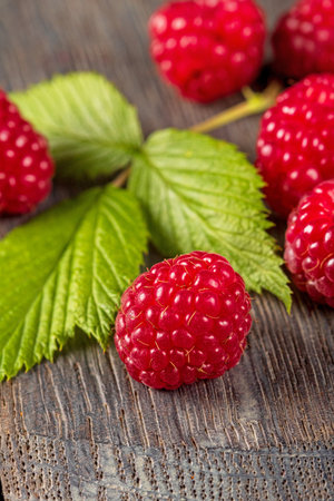 This stunning macro photo captures the vibrant color and texture of ripe raspberry berries nestled...