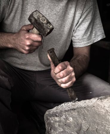 Hands of a farmer making a joint in the stone