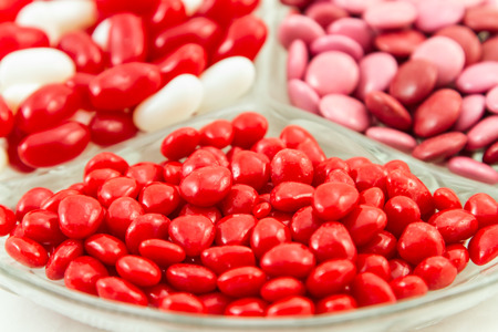 Assorted Valentines Day candies of cinnamon hearts, Valentine smarties and red and white jelly beansの写真素材
