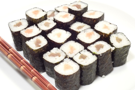 Salmon and tuna sushi rolls and red chopsticks isolated on white.の写真素材