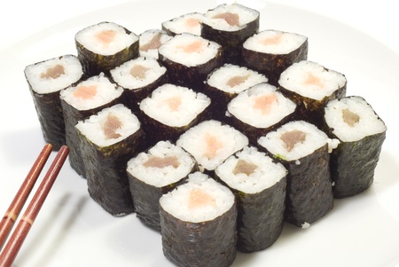 Salmon and tuna sushi on a white dish, red chopsticks on the left side.の写真素材