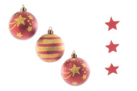 Three christmas balls and three red stars isolated on white. Strong glowing back light.の写真素材